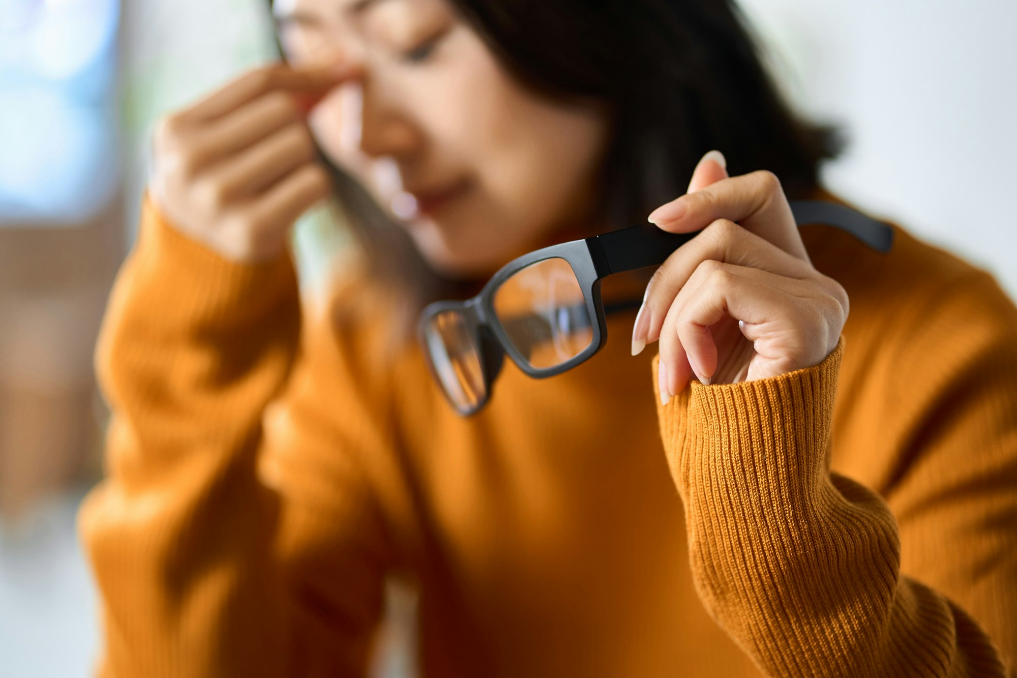 A woman who wears glasses and has tired eyes